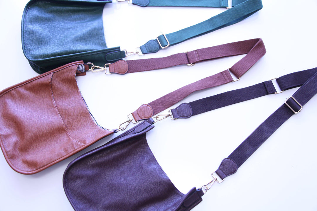 Three vegan leather messenger bags with adjustable straps