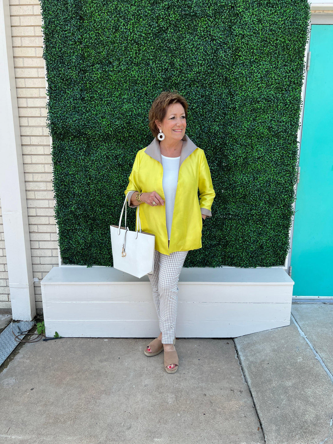 Très Chic women's boutique owner models the tan and white pants 